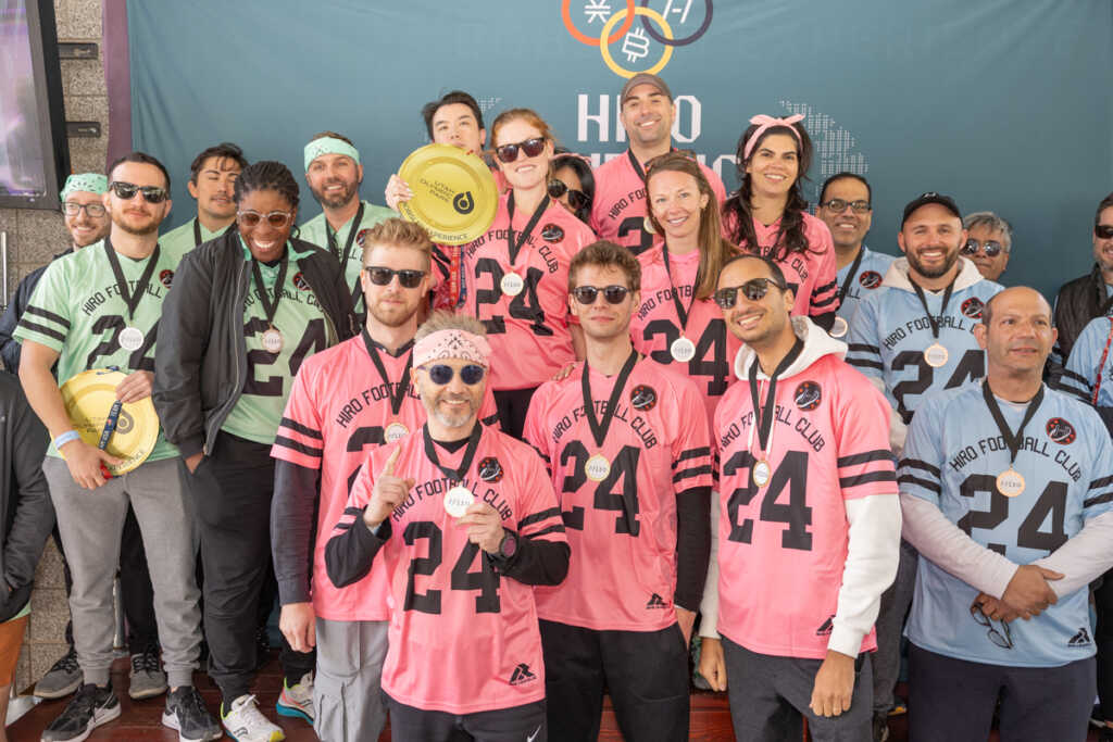 Hiro systems team posing with their jerseys and medals (sports themed)