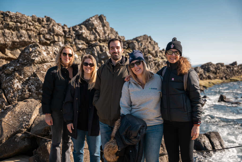 Fonoa team, ocean side shot with rocky cliffs in the background